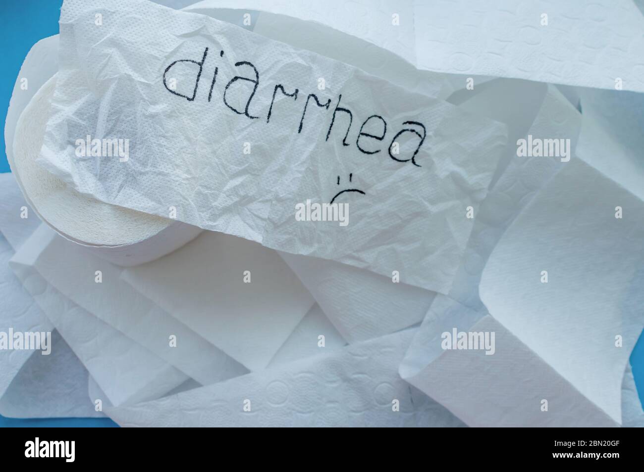 Rotoli di carta igienica bianca etichettata 'diarrea' su sfondo blu. Primo piano. Foto Stock
