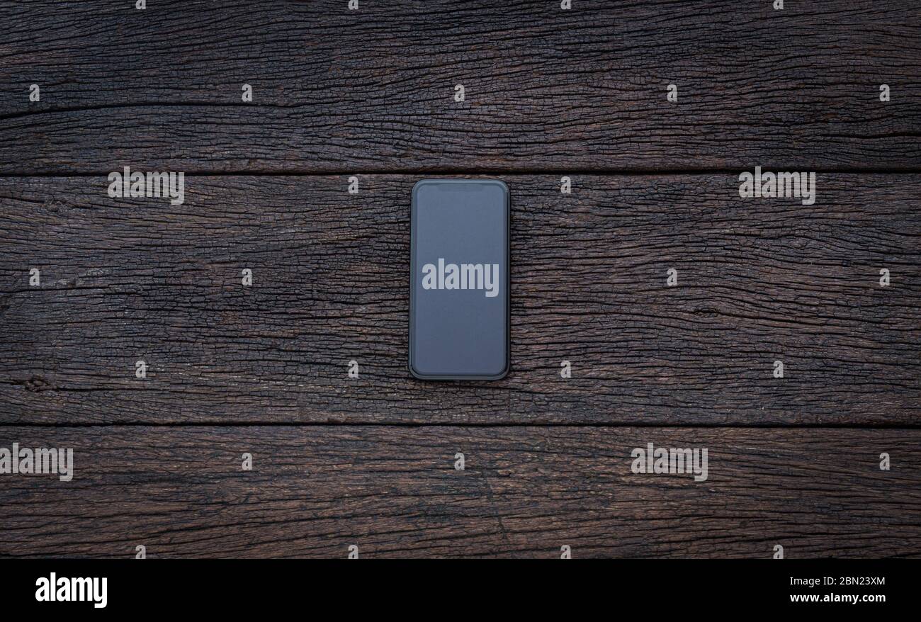 Vintage smartphone mockup piatto posare su vecchio tavolo in legno sfondo legno texture spazio concetto spazio lavoro ufficio vuoto display vista. Foto Stock