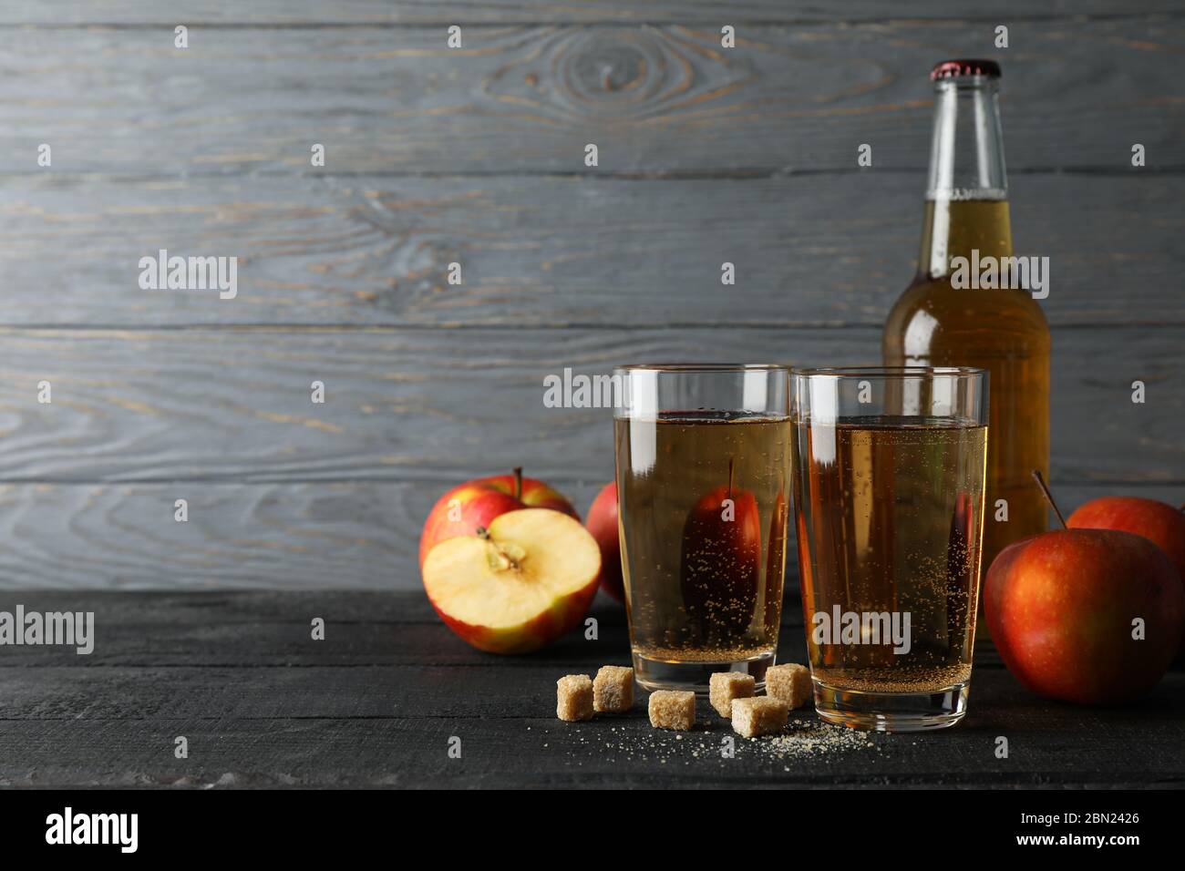 Composizione con sidro, zucchero e mele su fondo ligneo Foto Stock