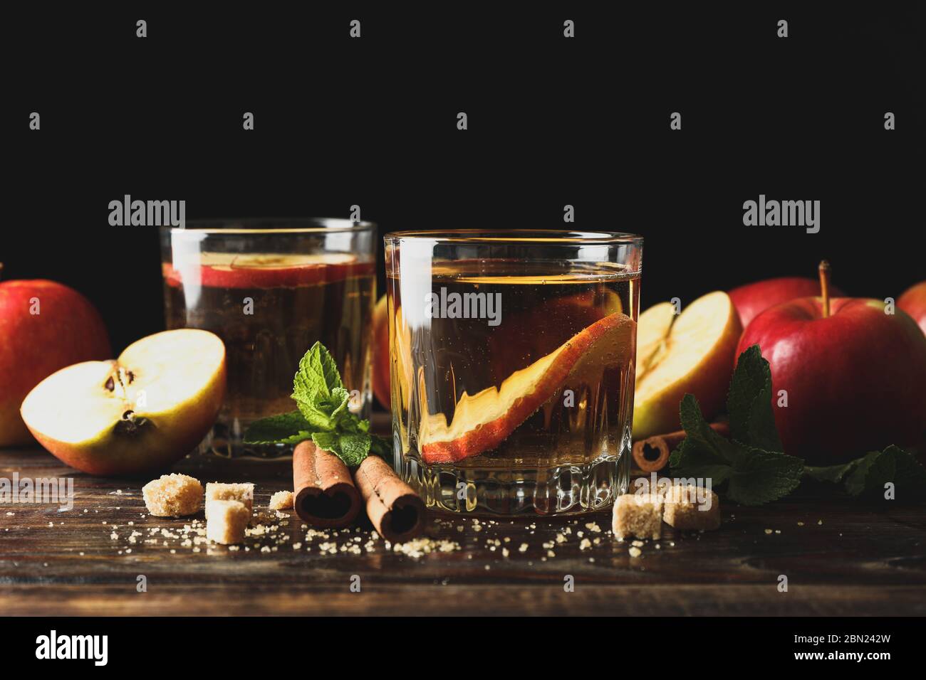 Composizione con sidro, zucchero, cannella e mele su tavola di legno Foto Stock
