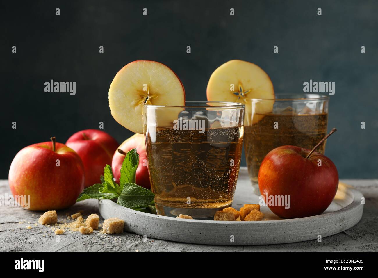 Composizione con sidro, zucchero e mele su tavola grigia Foto Stock