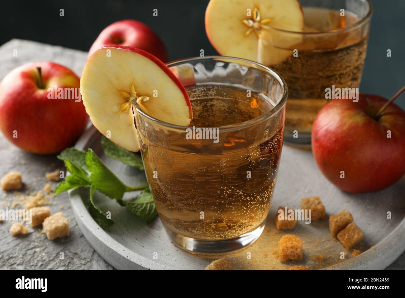 Composizione con sidro, zucchero e mele su tavola grigia Foto Stock