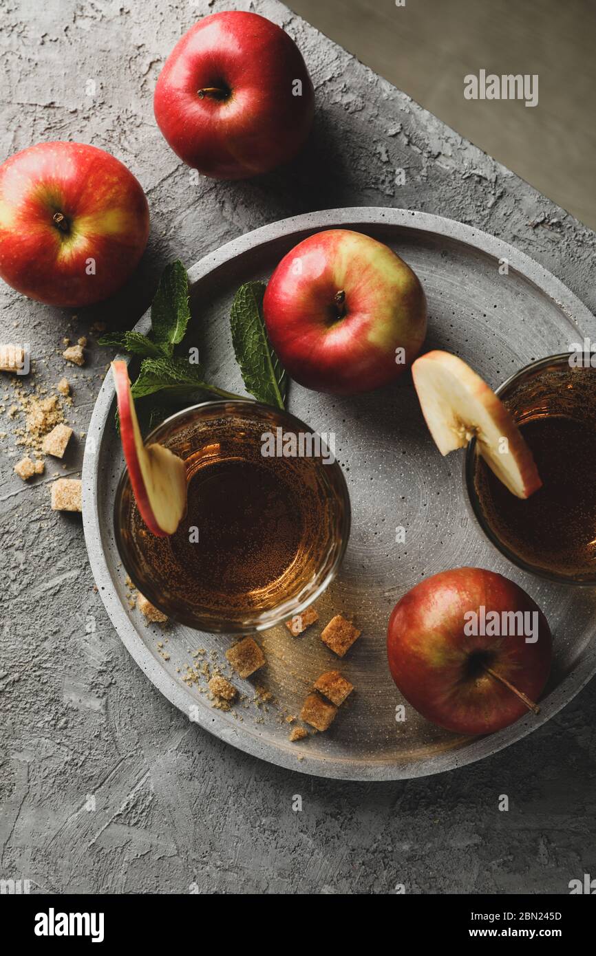 Composizione con sidro, zucchero e mele su tavola grigia Foto Stock