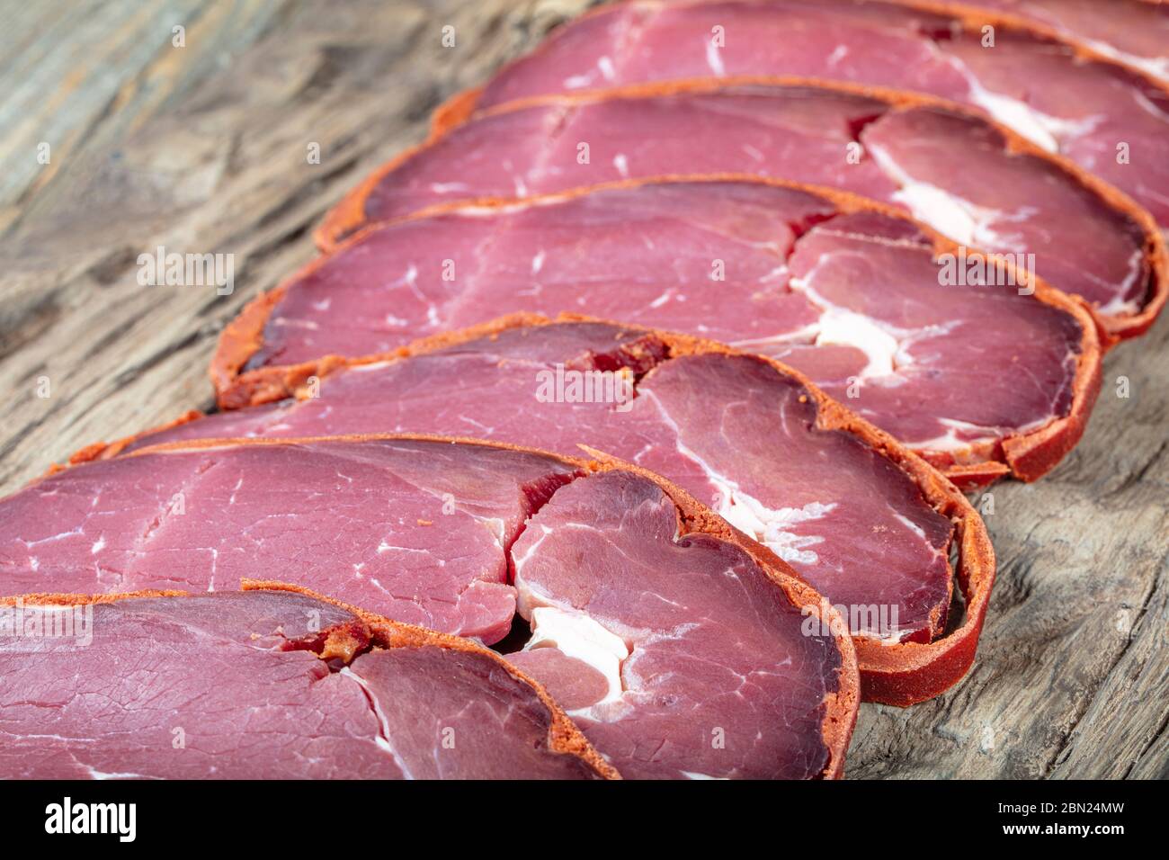 Pastrami di pancetta turca, pastrami di manzo affettati ( kayseri pastirma ) pastrami freschi affettati su sfondo di legno. Foto Stock