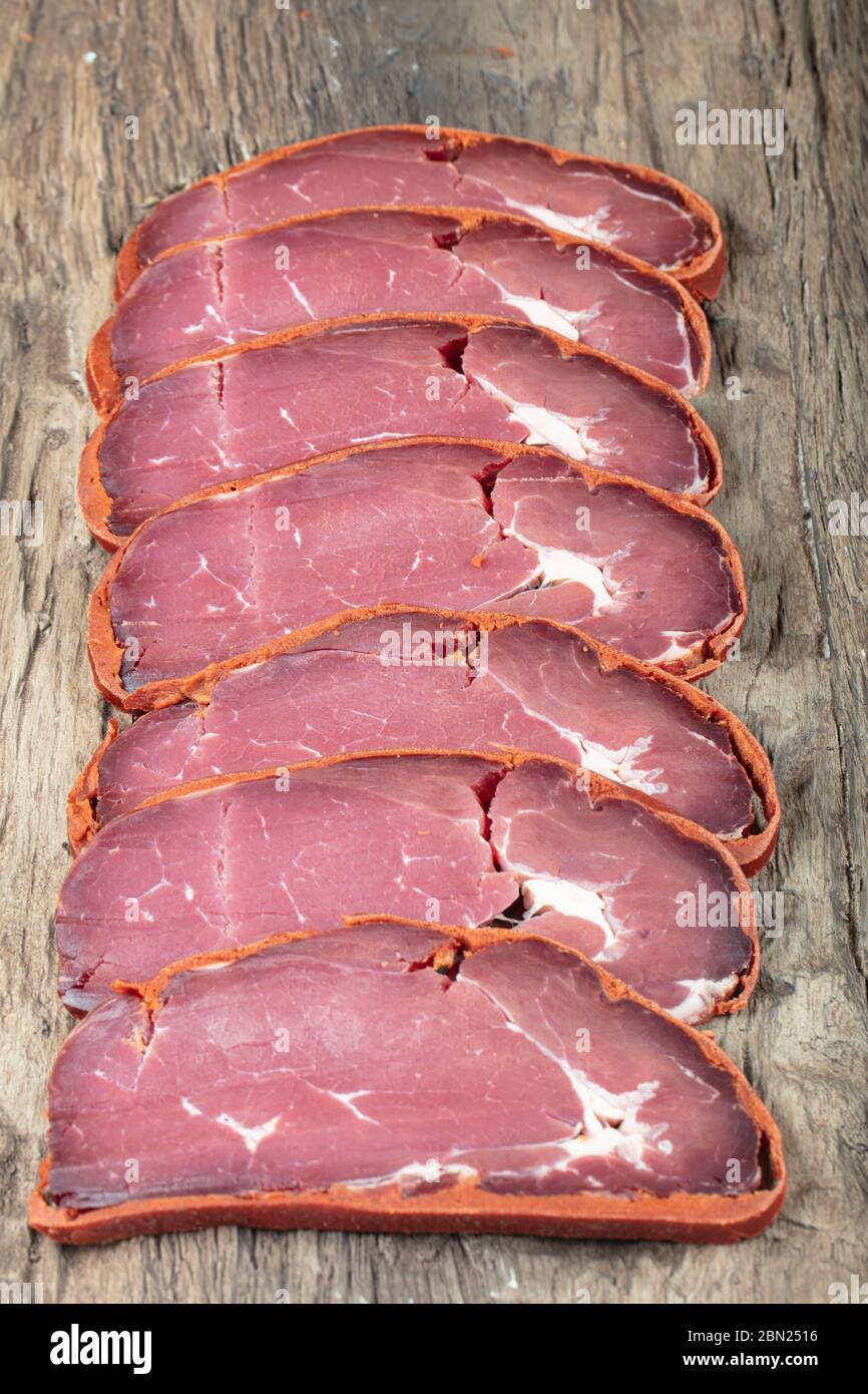 Pastrami di pancetta turca, pastrami di manzo affettati ( kayseri pastirma ) pastrami freschi affettati su sfondo di legno. Foto Stock