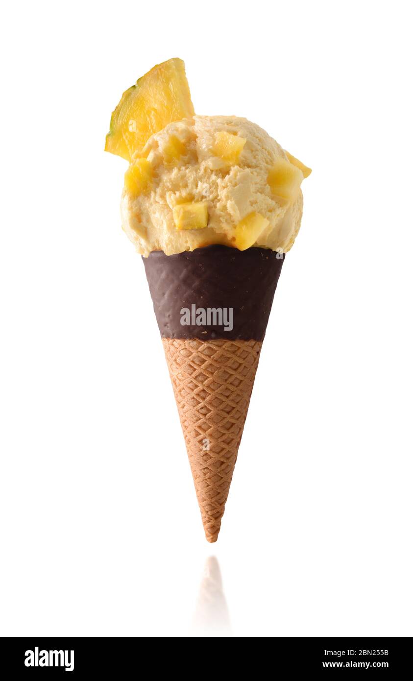 Gelato all'ananas con pezzi di frutta isolato su fondo bianco semi-immerso cono di cioccolato Foto Stock