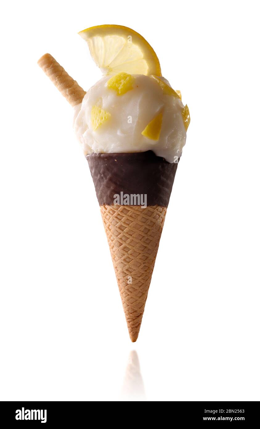 Gelato al limone con pezzi di frutta isolato su fondo bianco semi-immerso cono di cioccolato Foto Stock
