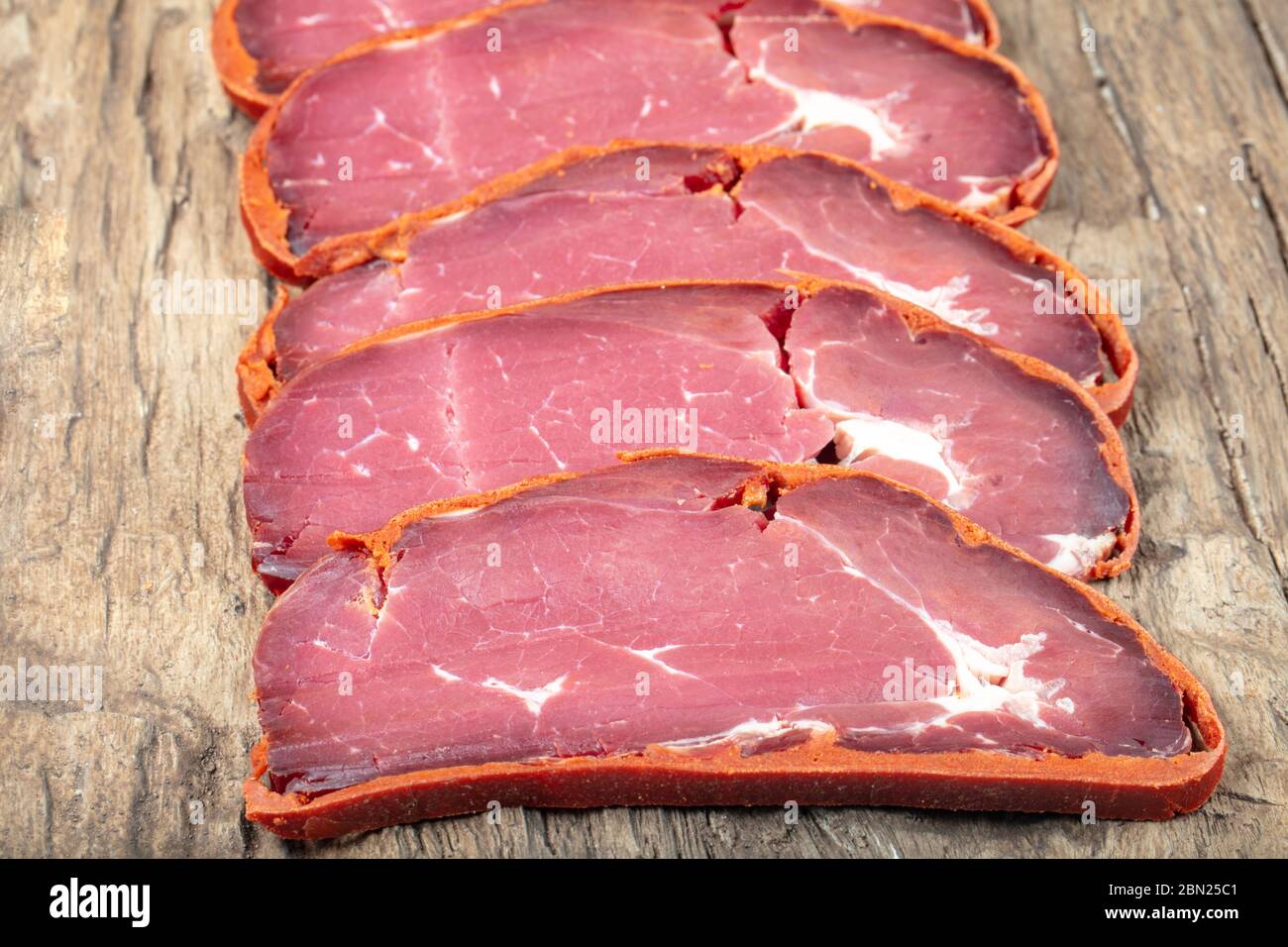 Pastrami di pancetta turca, pastrami di manzo affettati ( kayseri pastirma ) pastrami freschi affettati su sfondo di legno. Foto Stock