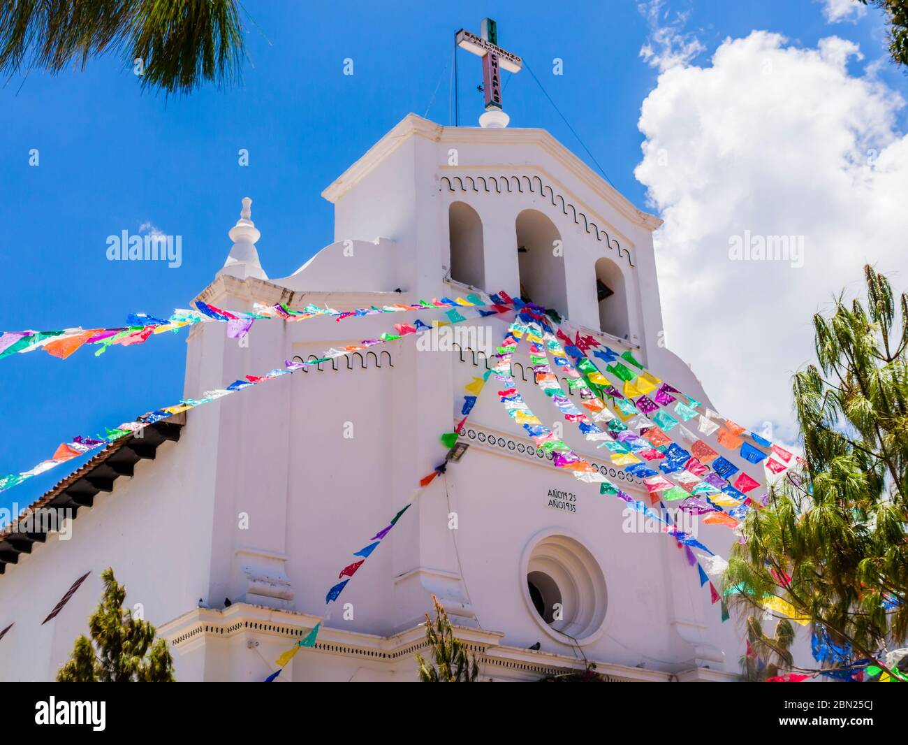 Vista prospettica della chiesa di San Lorenzo e delle sue colorate bandiere di preghiera , Zinacantan, Chiapas, Messico Foto Stock