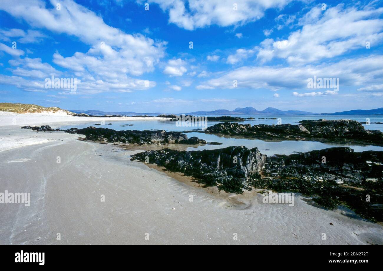 Vuota spiaggia di sabbia bianca vicino allo Strand sull'Isola Ebrida di Colonsay in estate con l'Isola e i Pap del Giura all'orizzonte, Scozia, Regno Unito Foto Stock