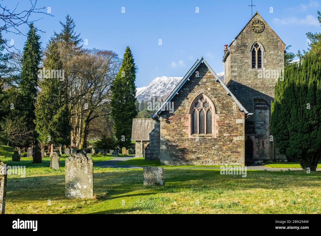 St Patrick's Church Patterdale con il Lake District innevato campane sullo sfondo Foto Stock