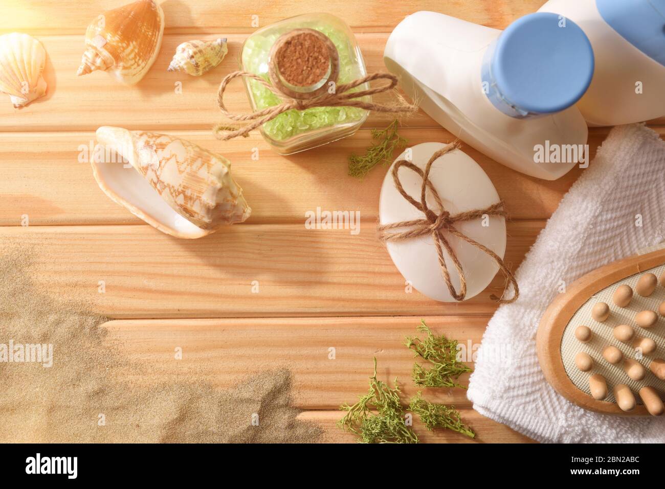 Prodotti talassoterapici per trattamenti corpo su stecche di legno decorate con conchiglie di alghe e sabbia. Vista dall'alto. Composizione orizzontale. Foto Stock