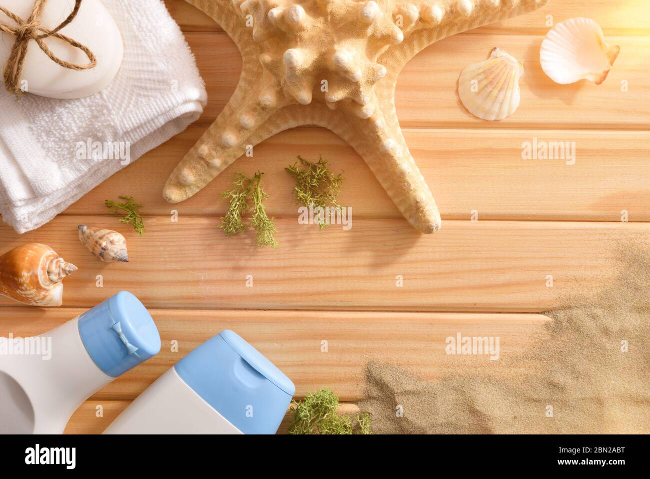 Prodotti per talassoterapia per trattamenti corpo su stecche di legno decorate con conchiglie di alghe e sabbia di stelle marine. Vista dall'alto. Composizione orizzontale. Foto Stock