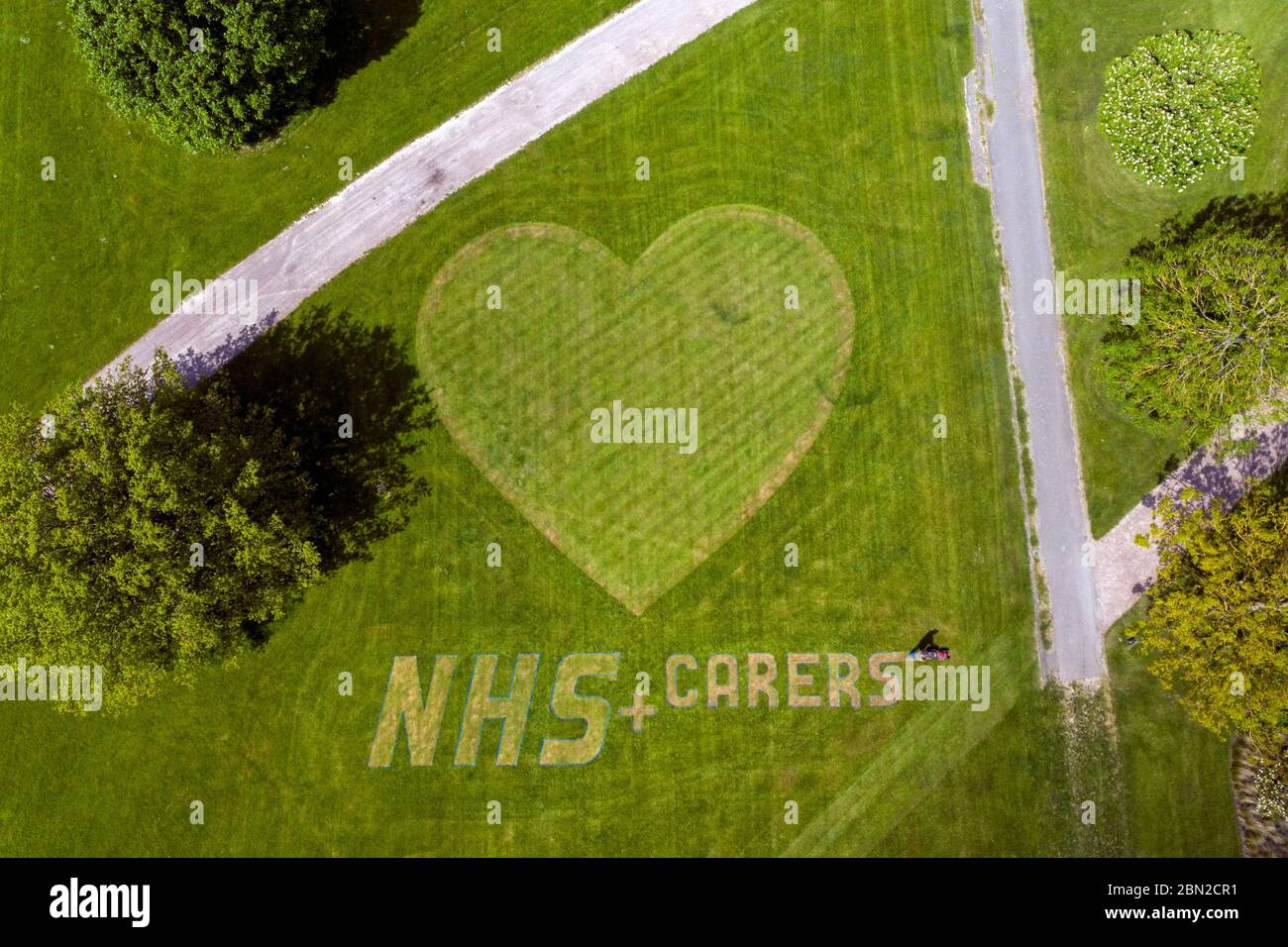 L'orticoltore di macchinari e di tappeti Turf Nigel Downs mette il tocco finale a un messaggio di ringraziamento per il personale e gli accompagnatori del NHS Hyde Hall Gardens a Chelmsford, Essex. Foto Stock