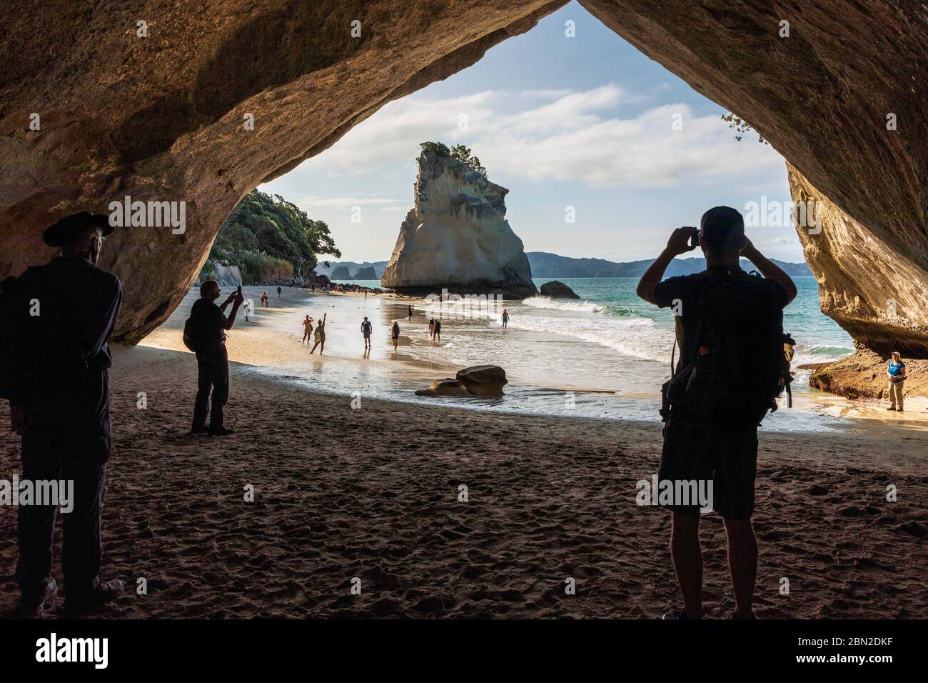 Turisti che scattano foto a Cathedral Cove, Penisola di Coromandel, Waikato, Isola del Nord, Nuova Zelanda Foto Stock