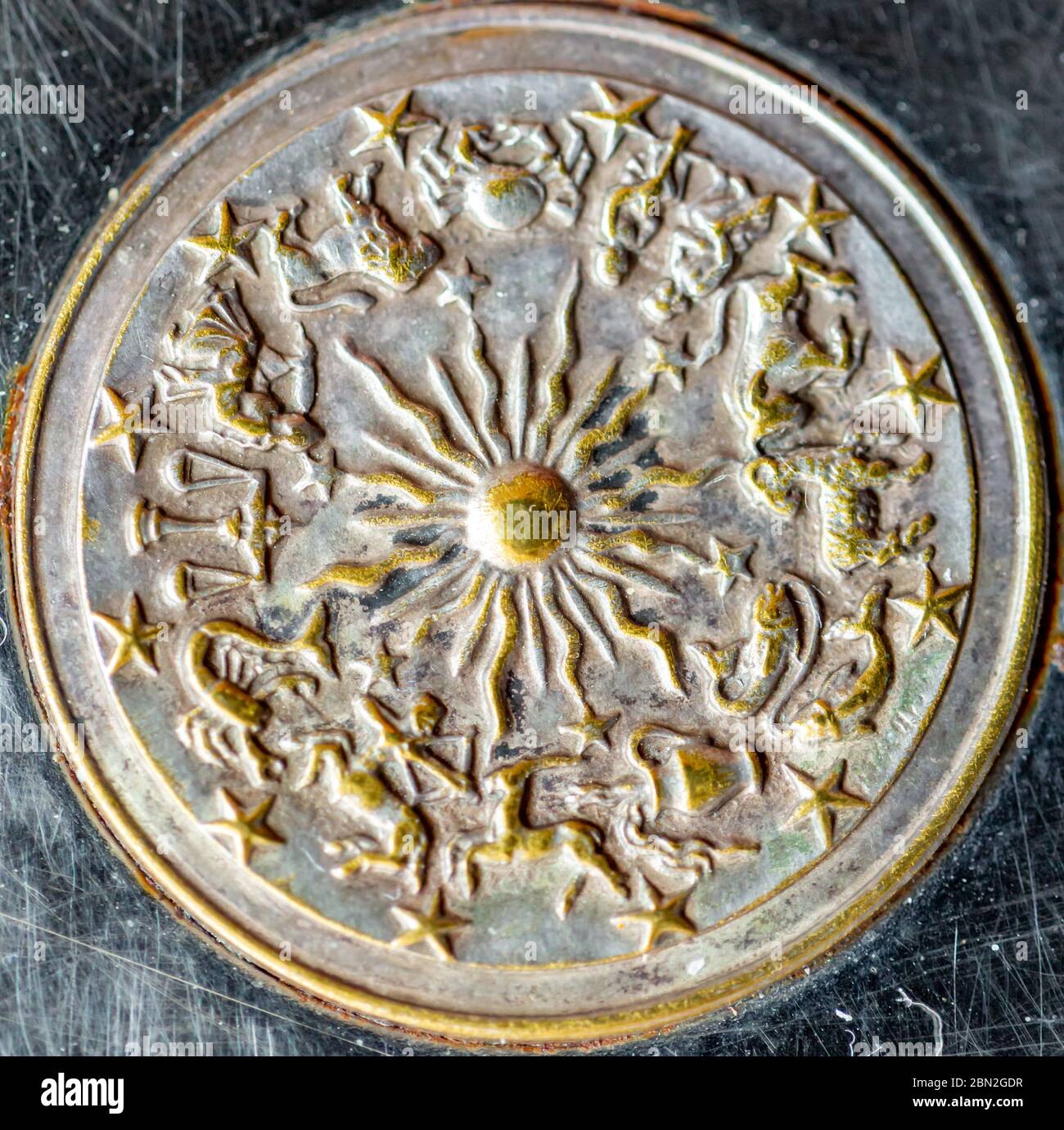 simbolo di metallo rotondo di uno zodiaco con il sole al centro Foto Stock