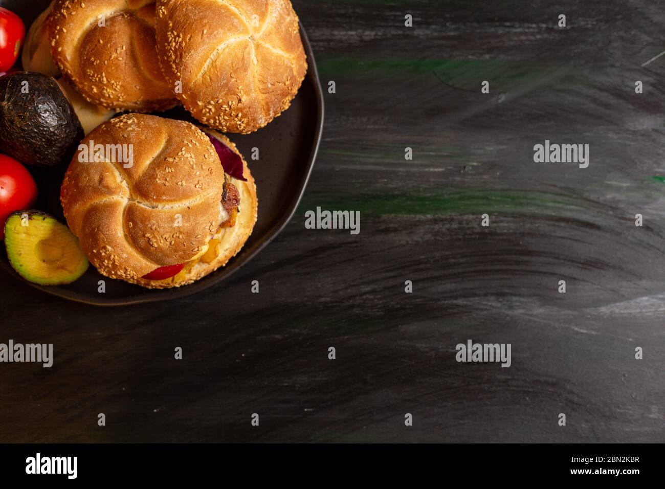 Kaiser con hamburger, formaggio di pomodoro, avocado, lattuga. Può essere preparato o mangiato separatamente. Foto Stock