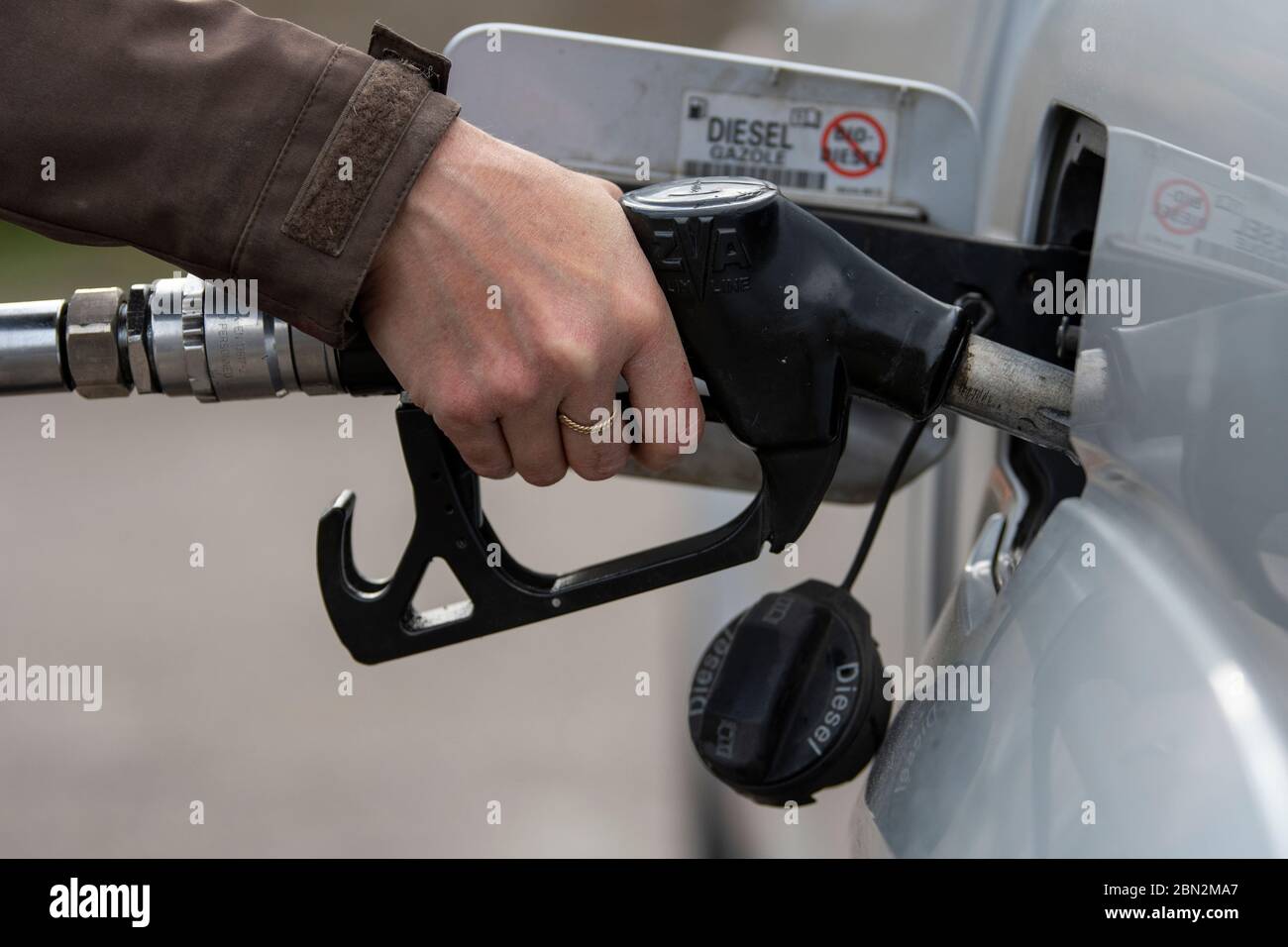 Donna che mette il combustibile diesel nella sua automobile ad una stazione di combustibile. North Yorkshire, Regno Unito. Foto Stock