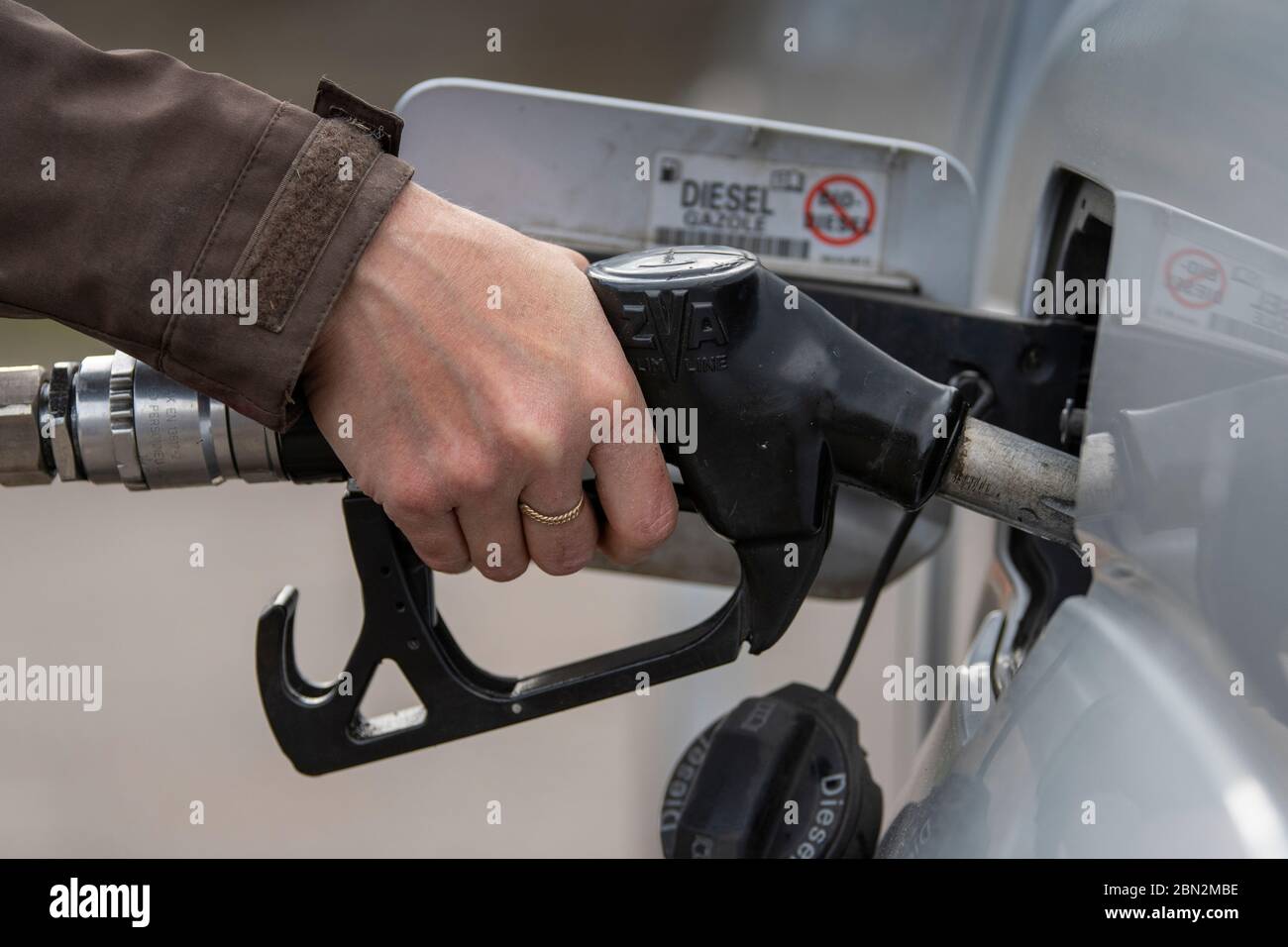 Donna che mette il combustibile diesel nella sua automobile ad una stazione di combustibile. North Yorkshire, Regno Unito. Foto Stock