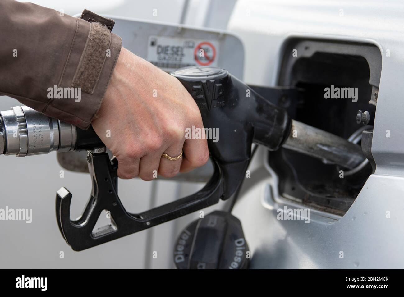Donna che mette il combustibile diesel nella sua automobile ad una stazione di combustibile. North Yorkshire, Regno Unito. Foto Stock