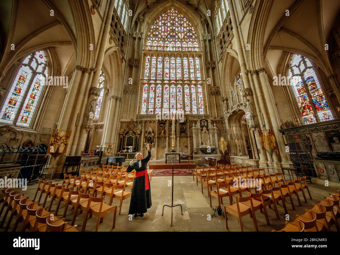 Canon Maggie McLean, canonico missionario a York Minster, accende la candela pasquale come clero alla cattedrale ha lanciato una nuova iniziativa per utilizzare la candela come un fuoco per la preghiera per tutti coloro che sono colpiti dalla pandemia di Coronavirus. Foto Stock