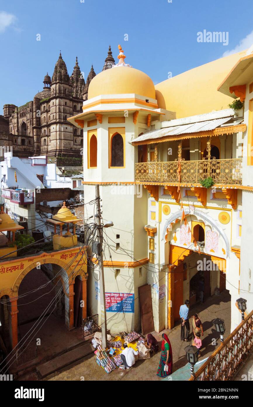 Orchha, Madhya Pradesh, India : la gente cammina attraverso una porta della città ornata con il Tempio di Chaturbhuj sullo sfondo. Il tempio del IX secolo è un complesso mul Foto Stock