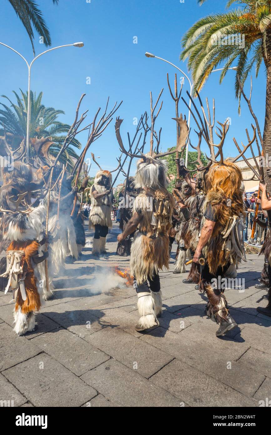 Sardegna festival Sassari, un gruppo di cacciatori vestiti di pelli di animali partecipare al gran processione durante la Cavalcata di Sassari, Sardegna. Foto Stock