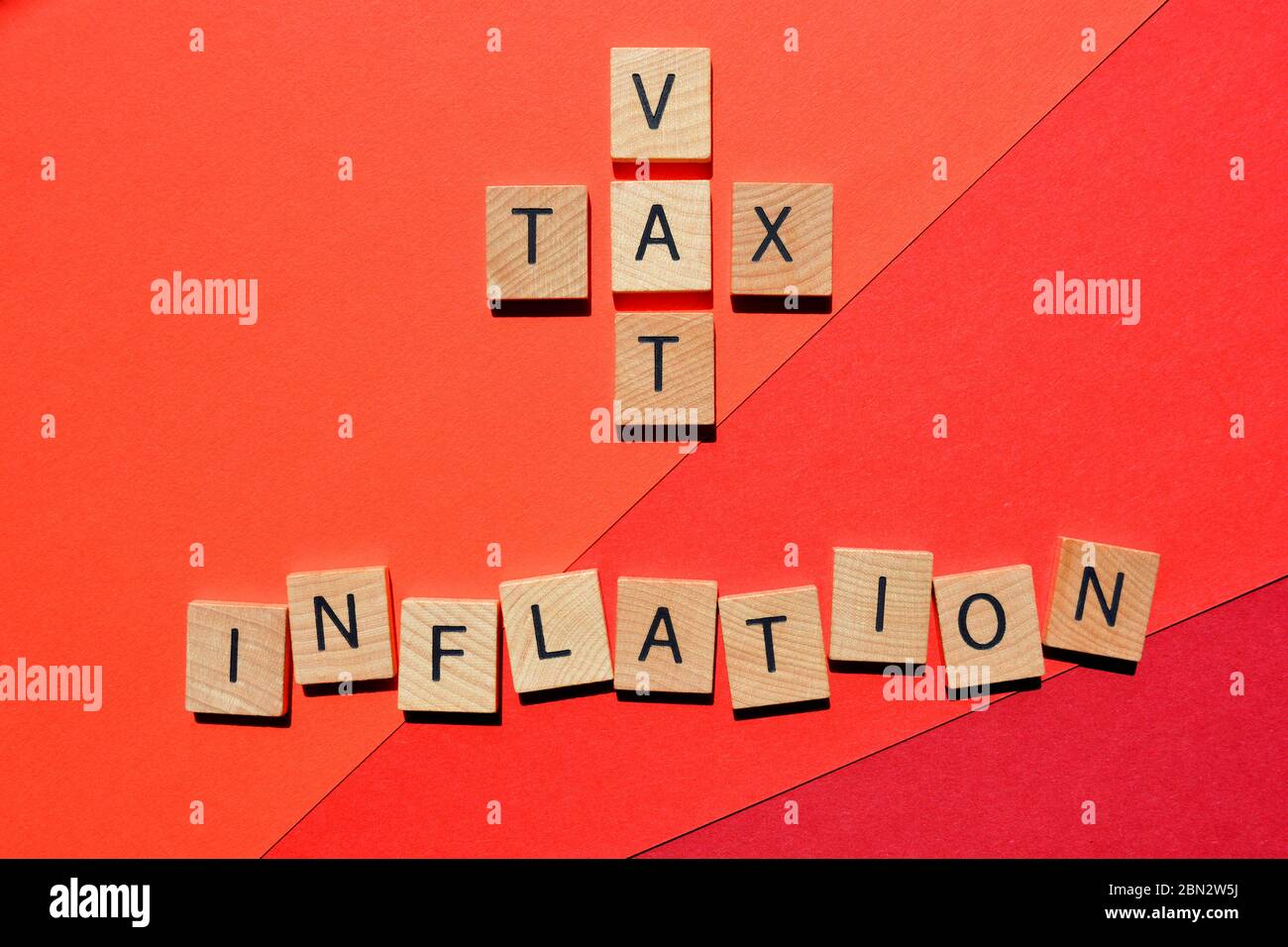 IVA e imposte in forma di crossword con la parola inflazione su sfondo rosso Foto Stock