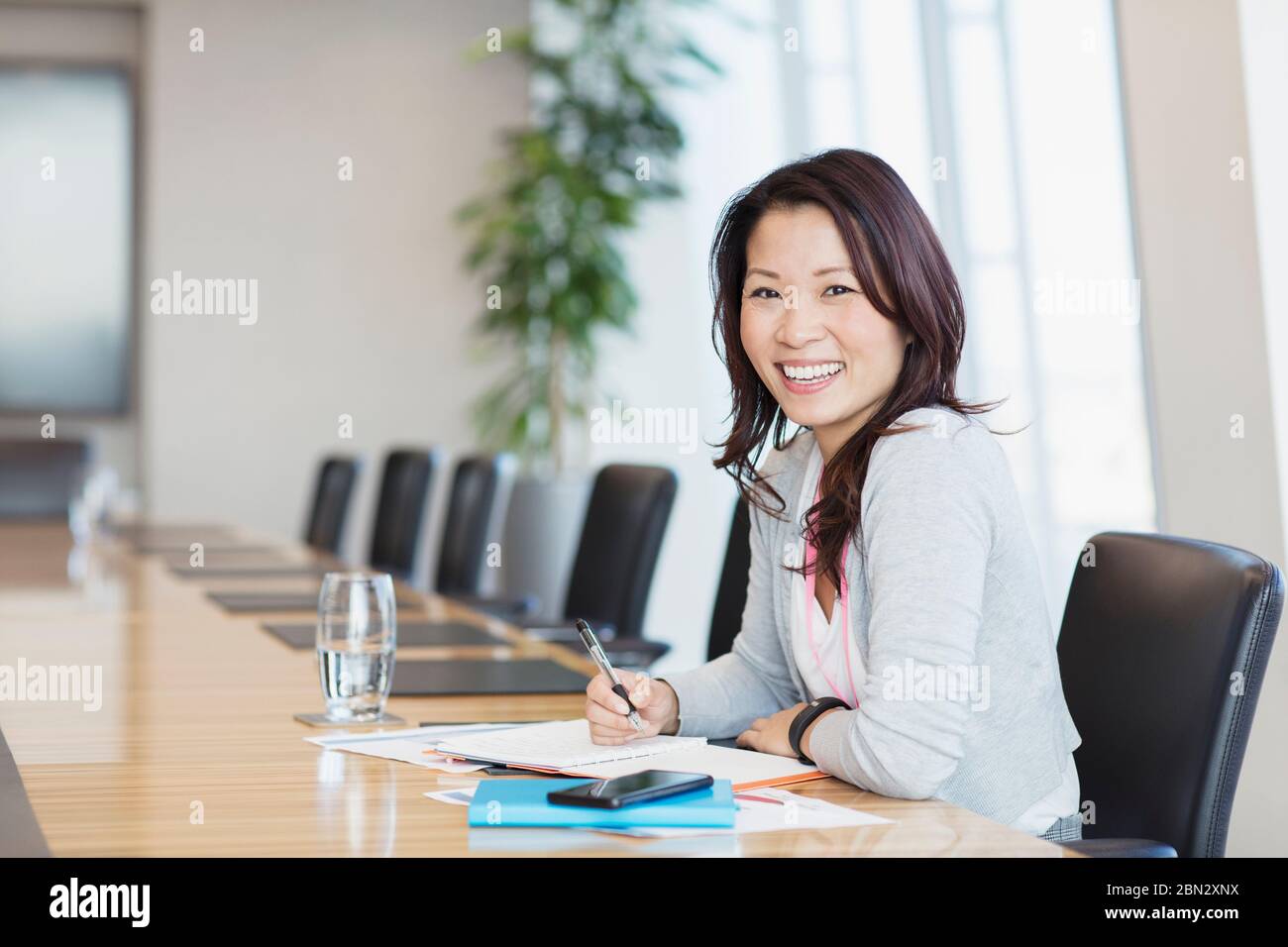 Ritratto sicuro sorridente donna d'affari che lavora in sala conferenze Foto Stock