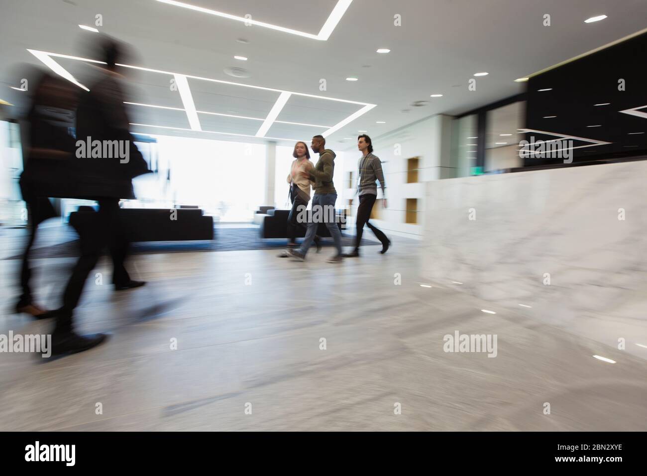 La gente di affari a piedi nella lobby di office Foto Stock