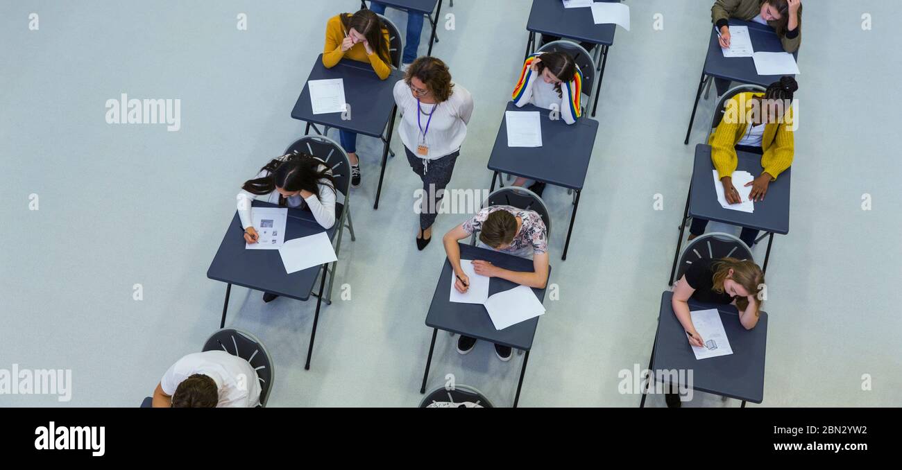 Vista dall'alto degli insegnanti di scuola superiore che sovrintende agli studenti che stanno prendendo l'esame Foto Stock