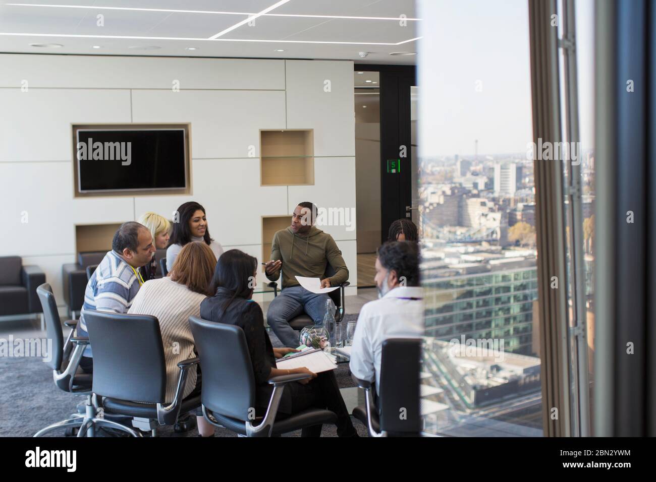 Gli uomini d'affari parlano in cerchio nella sala riunioni Foto Stock