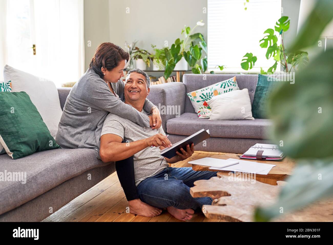 Affettuosa coppia matura che legge e parla in soggiorno Foto Stock