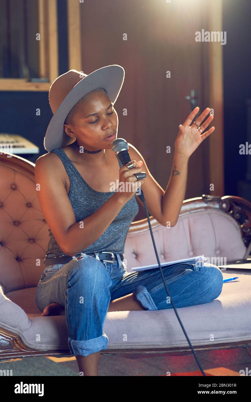 Musicista femminile che canta nel microfono in studio di registrazione Foto Stock