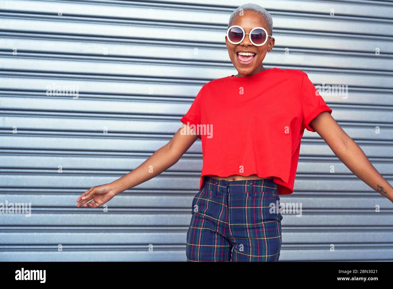 Ritratto giovane donna spensierata che indossa occhiali da sole Foto Stock