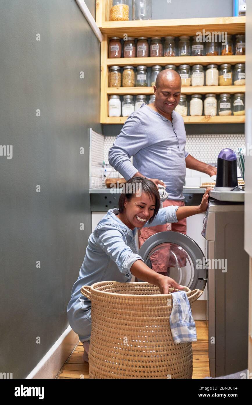Felice coppia facendo lavanderia in cucina Foto Stock