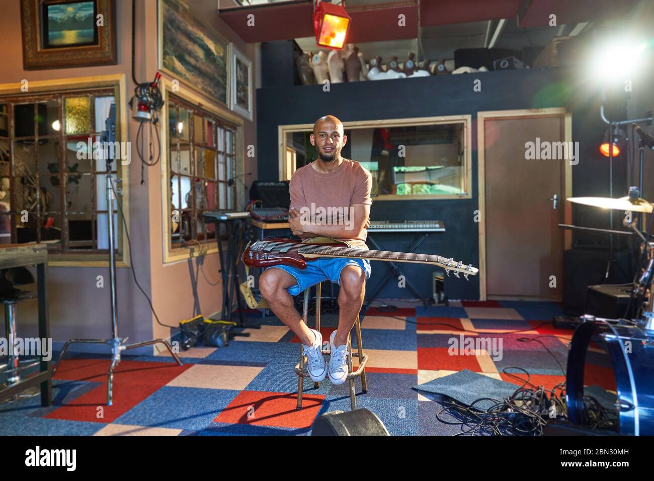 Musicista maschile con fiducia nel ritratto e chitarra in studio di registrazione Foto Stock