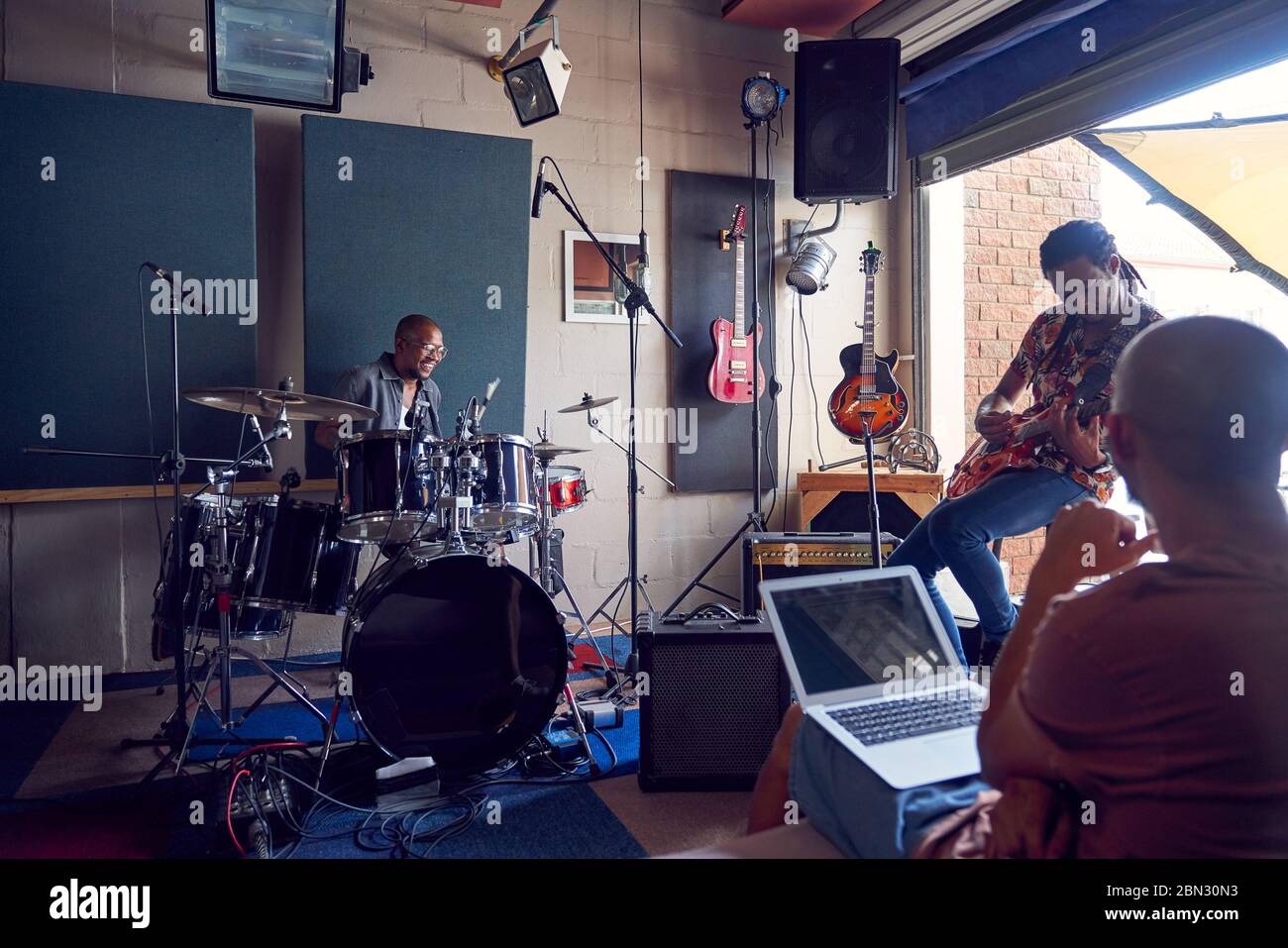 Musicisti che praticano in studio di registrazione musicale Foto Stock