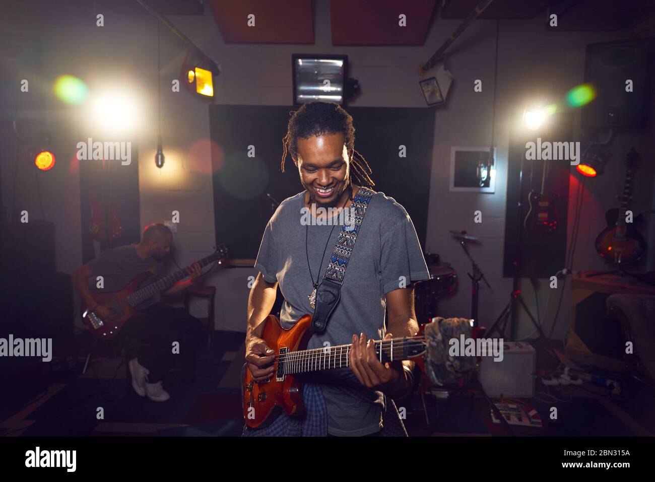 Musicista maschile che suona la chitarra in studio di registrazione Foto Stock