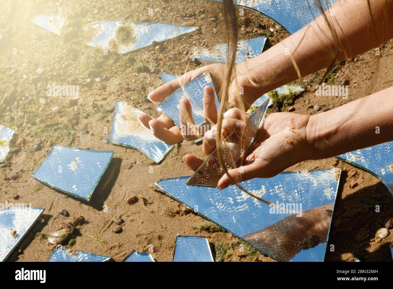 Mani femminili e molte protezioni degli specchi rotte Foto Stock