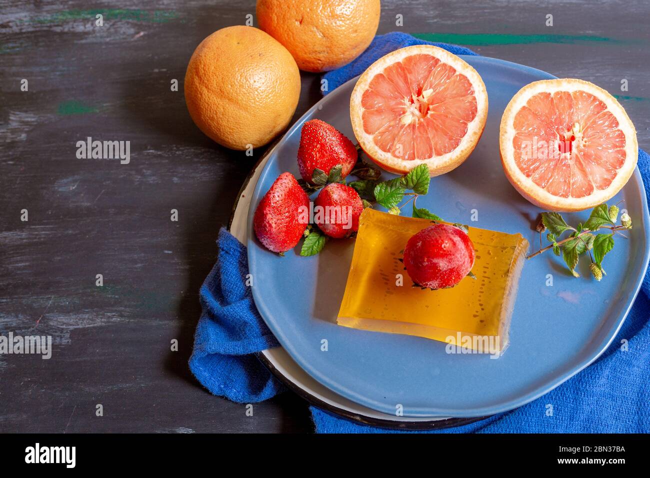 Pompelmo su sfondo blu e piatto decorato, per fare succhi di frutta o per godere in un pomeriggio a casa Foto Stock