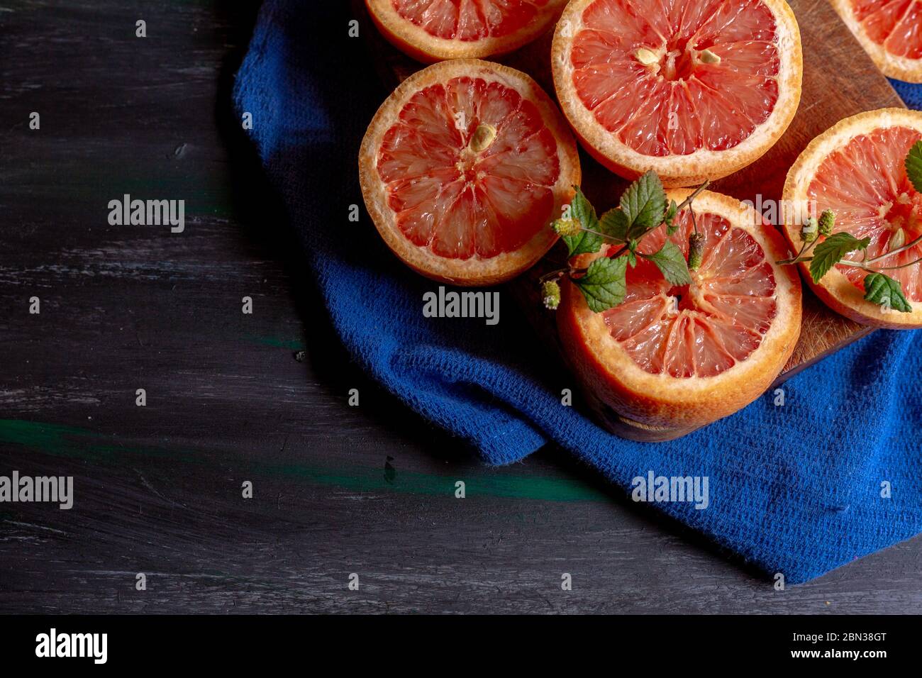 Pompelmo su sfondo blu e piatto decorato, per fare succhi di frutta o per godere in un pomeriggio a casa Foto Stock