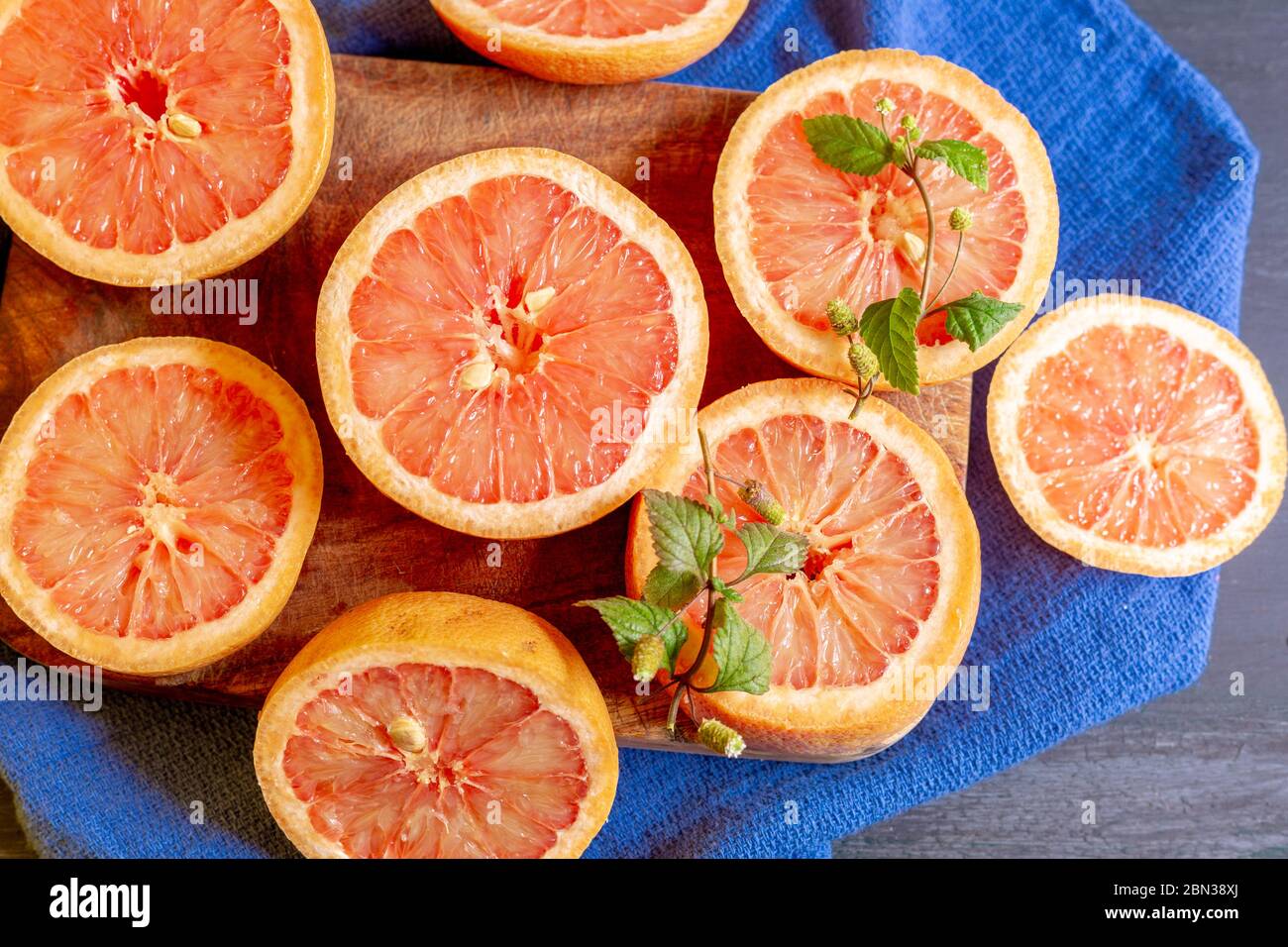 Pompelmo su sfondo blu e piatto decorato, per fare succhi di frutta o per godere in un pomeriggio a casa Foto Stock