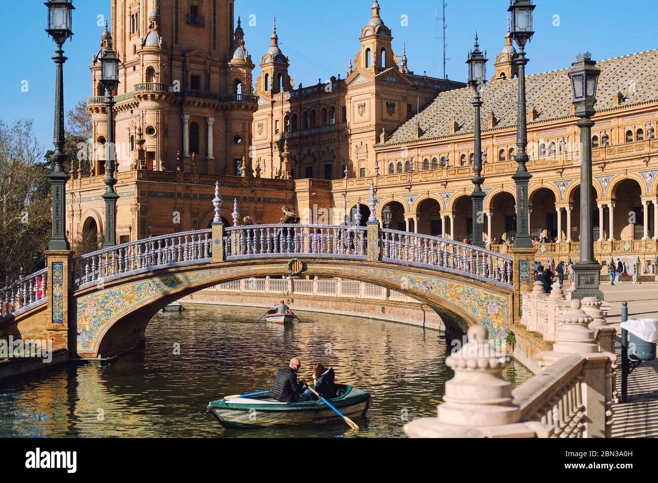 Siviglia, Spagna: 23 dicembre 2019: I turisti vanno in barca a remi intorno all'acqua del fiume Guadalquivir in Plaza de Espana. Giorno di sole, Siviglia, Spagna Foto Stock