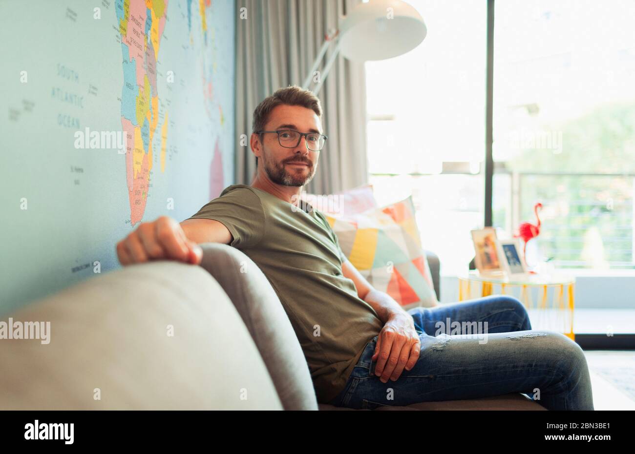 Uomo sicuro di ritratti seduto sul divano del soggiorno Foto Stock