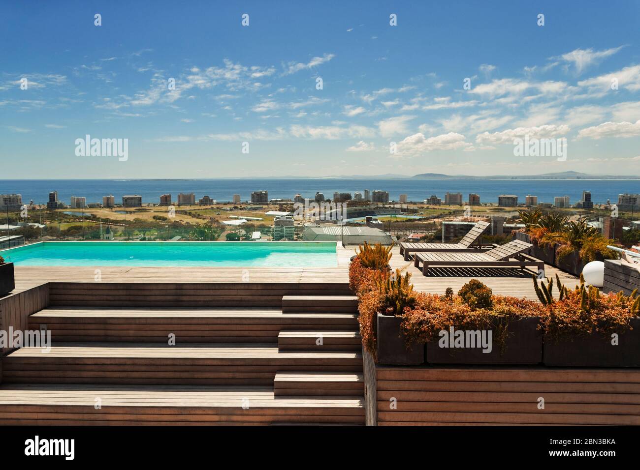 Piscina soleggiata e moderna sul tetto con vista oceano, Città del Capo, Sud Africa Foto Stock