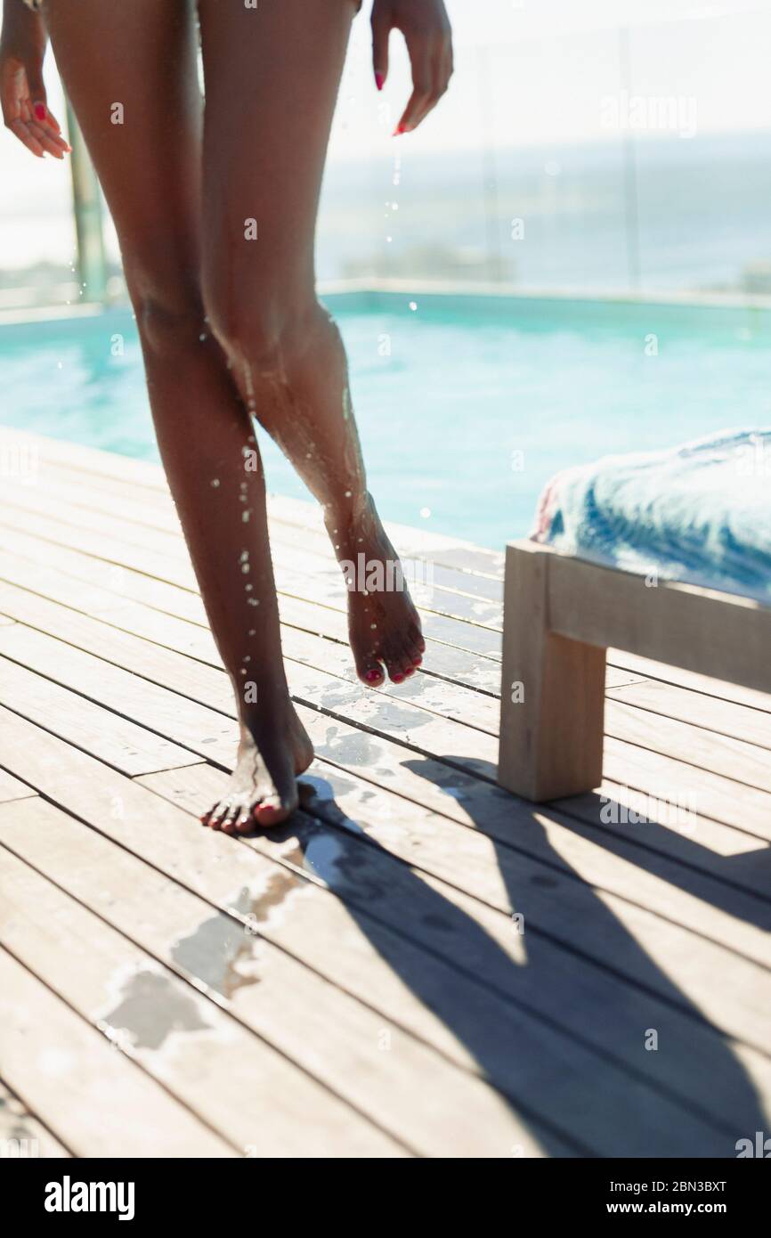 Donna che esce dalla piscina, sgocciolando acqua Foto Stock