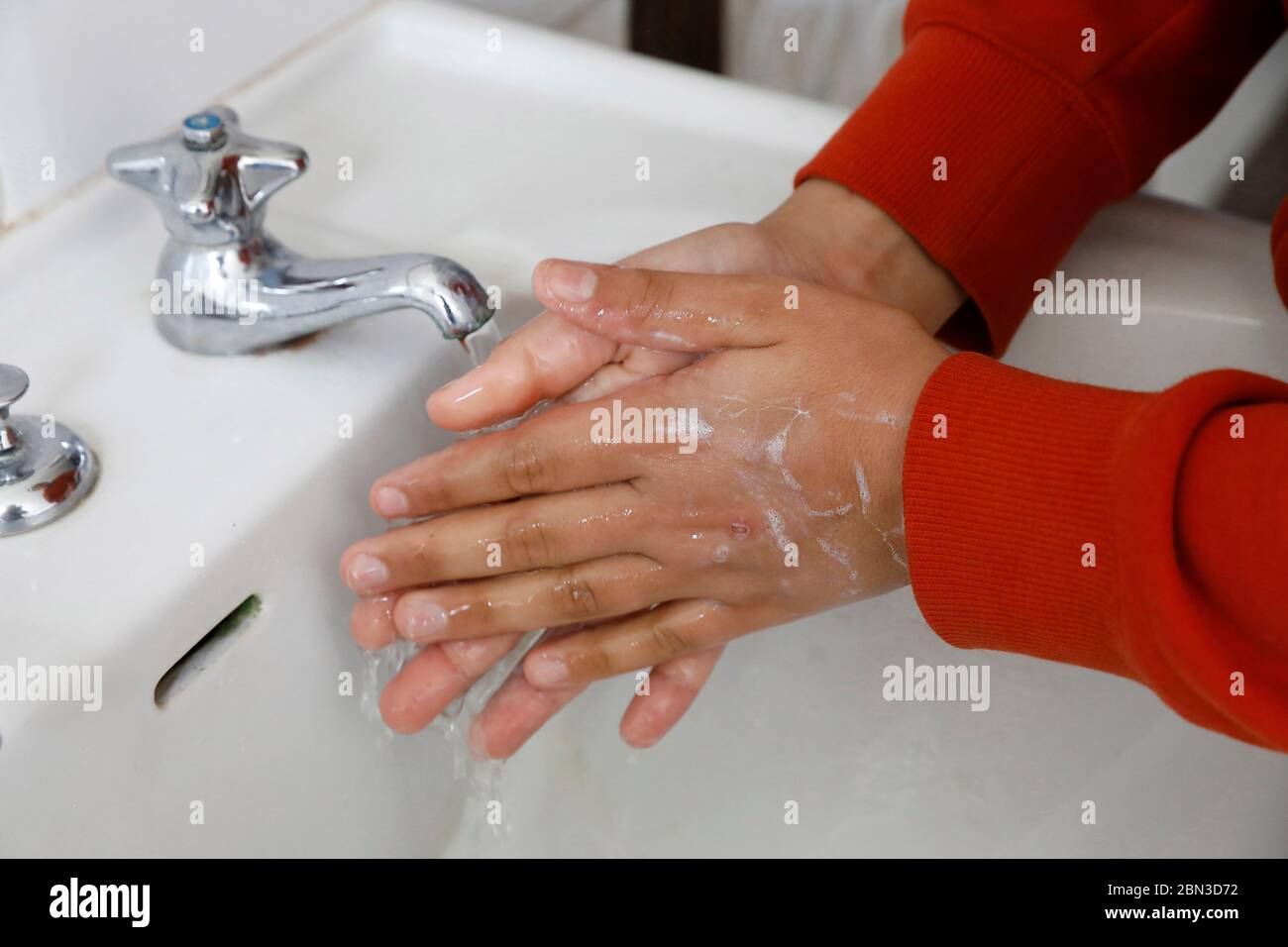 Adolescente che si lava le mani Foto Stock