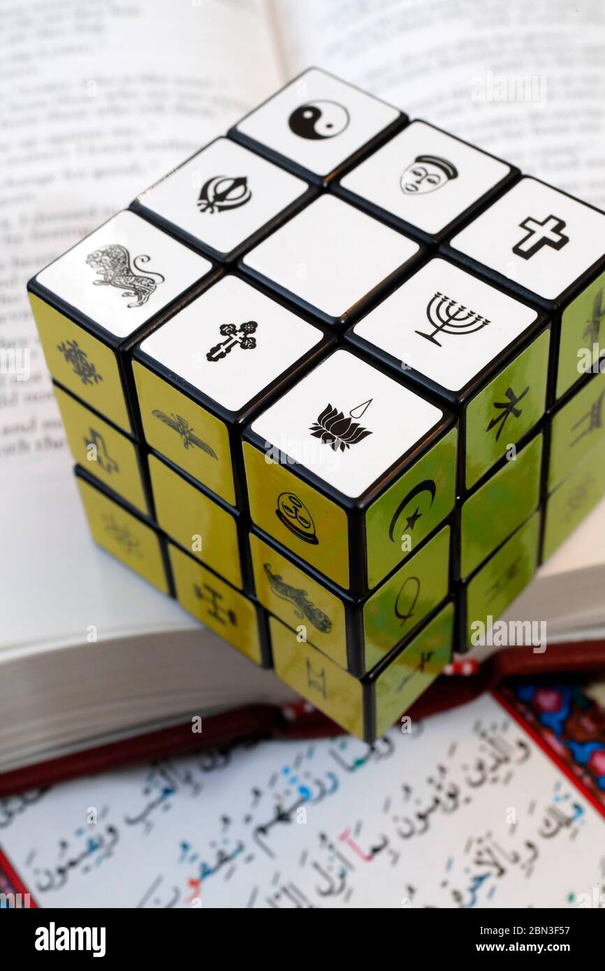 Quran, la Bibbia e il cubo di Rubik con simboli religiosi. Concetto di dialogo interreligioso e interreligioso. Foto Stock