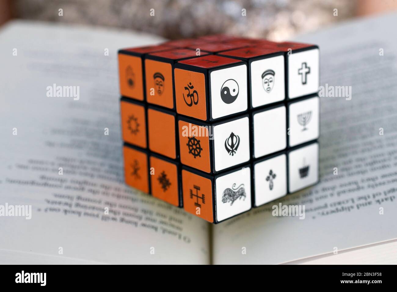 Bibbia e cubo di Rubik con simboli religiosi. Concetto di dialogo interreligioso e interreligioso. Foto Stock